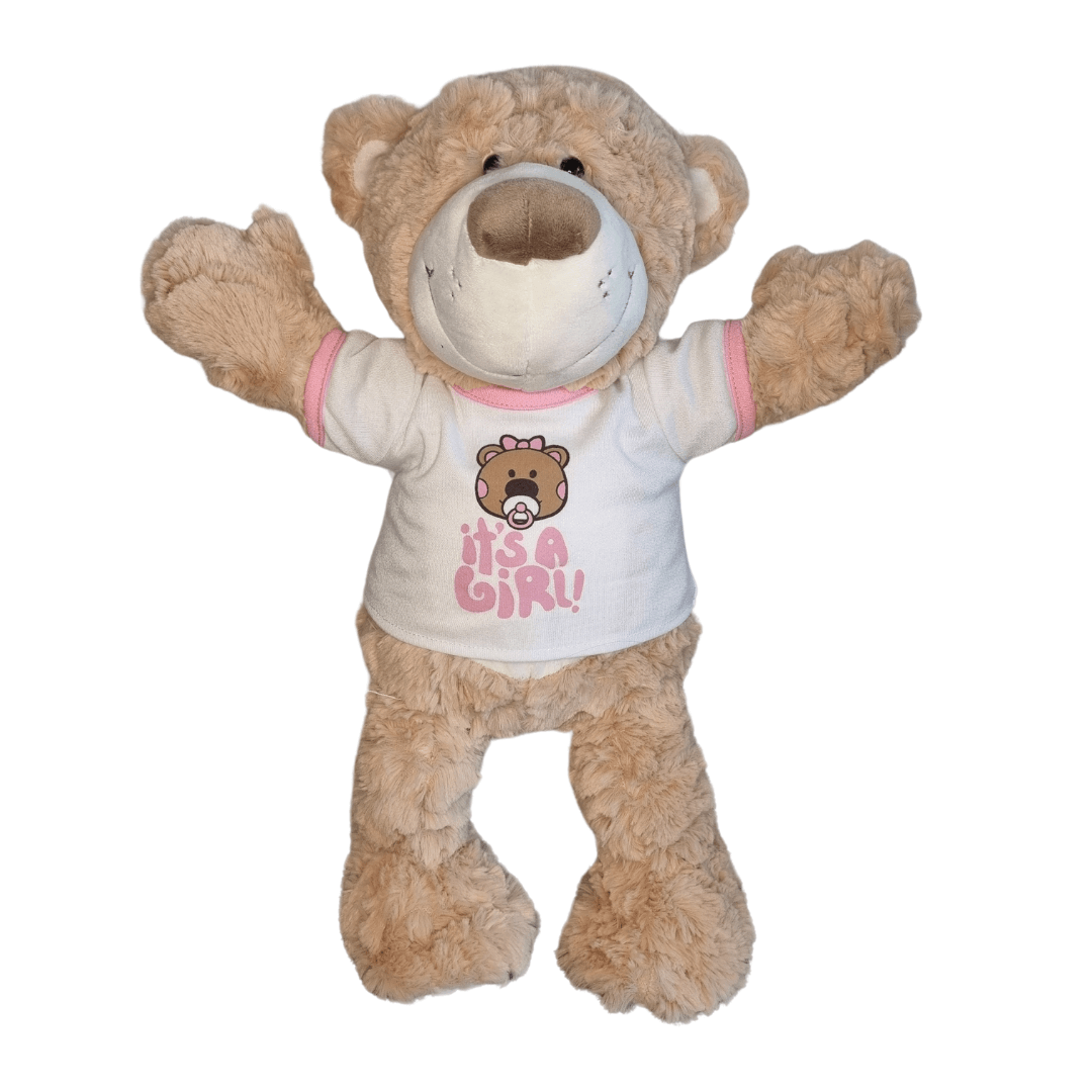 Knuffelbeer met "It's a Girl" T-shirt - Make a bearWit "It's a Girl" T-shirt voor knuffels, met roze tekst. Perfect voor het vieren van een geboorte. Hier heeft knuffel Milo de t-shirt aan